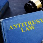 Antitrust law book and gavel on a desk.